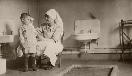 Krankenschwester pflegt ein krankes Kind in den Kolonien von Passay und Saint-Quentin für Flüchtlinge und Waisen, 1919